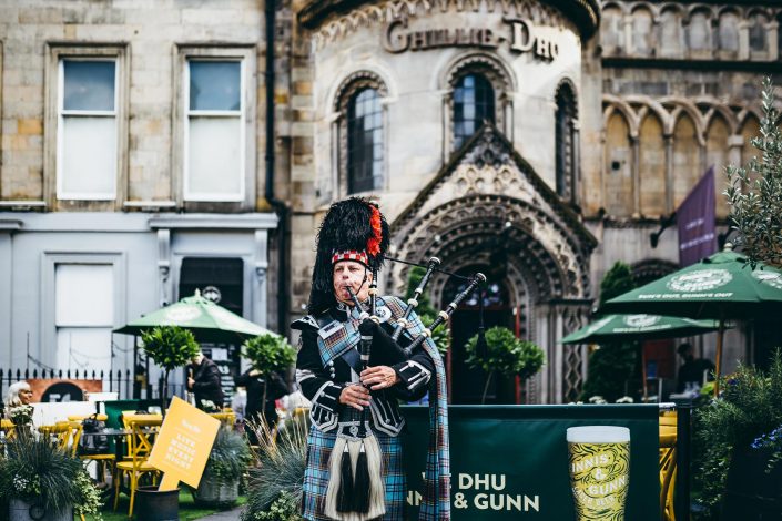 A bagpiper playing music outside Ghillie Dhu